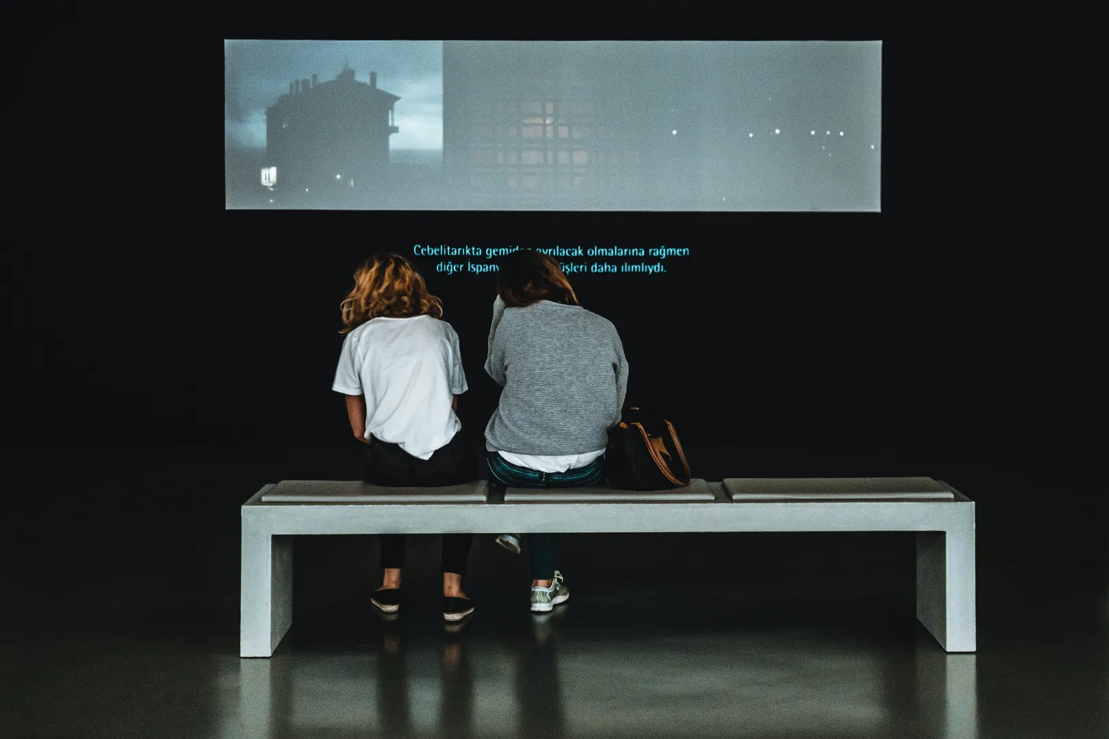 People looking at a projector screen in a gallery