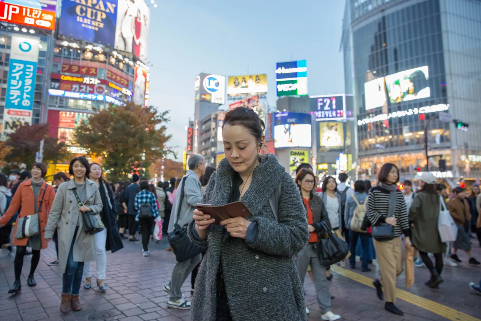 Woman checking her phone amid crowds at Shibuya Crossing, Tokyo, from Crowd DNA's Power of Audio study